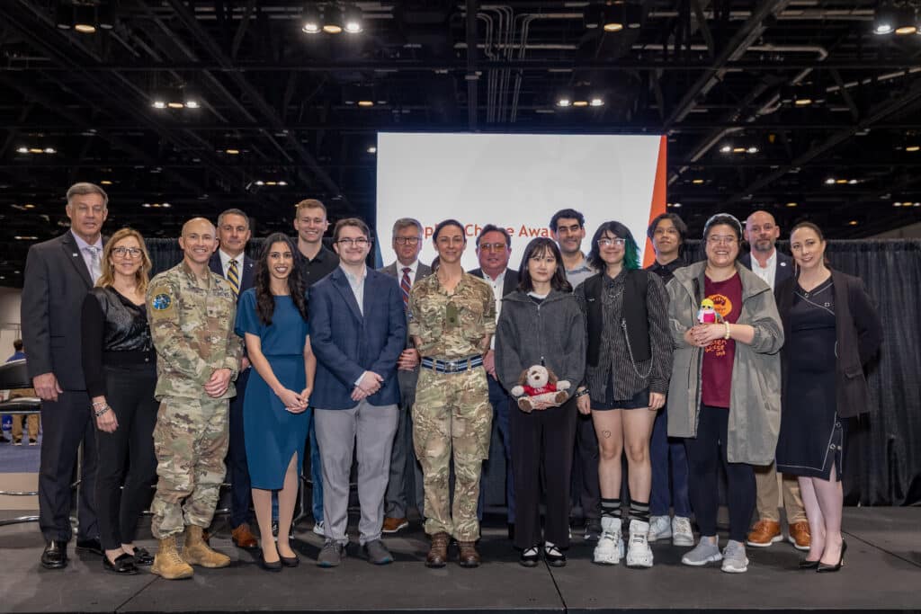 An image showing representatives from each of the winning games on stage with the SGS&C Director, 2025 IPT Lead, President NTSA, and the lead service executives from the USAF and USSF. 